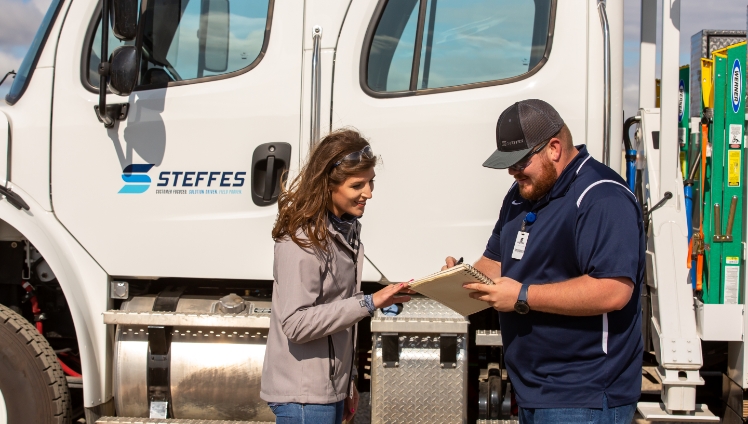 A photo of Steffes Key Account Managers having a conversation in front of a Steffes service truck